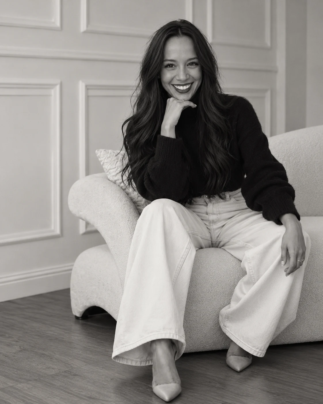 Black-and-white portrait of Genta seated in a light armchair