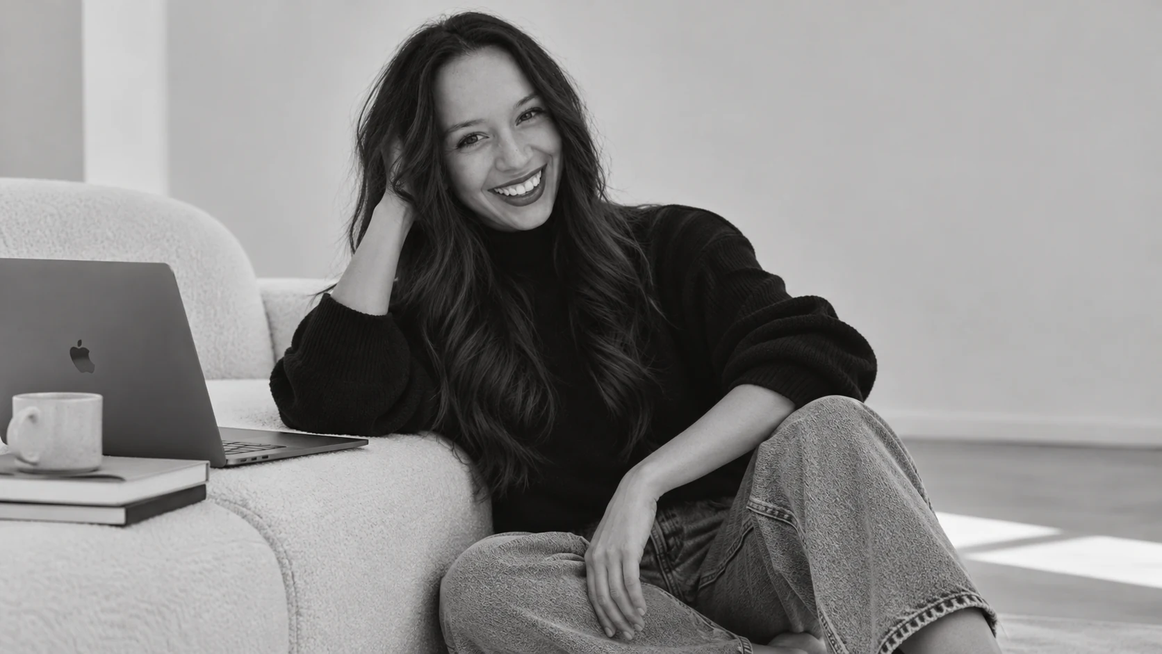 Genta Vazquez seated on a sofa with her laptop