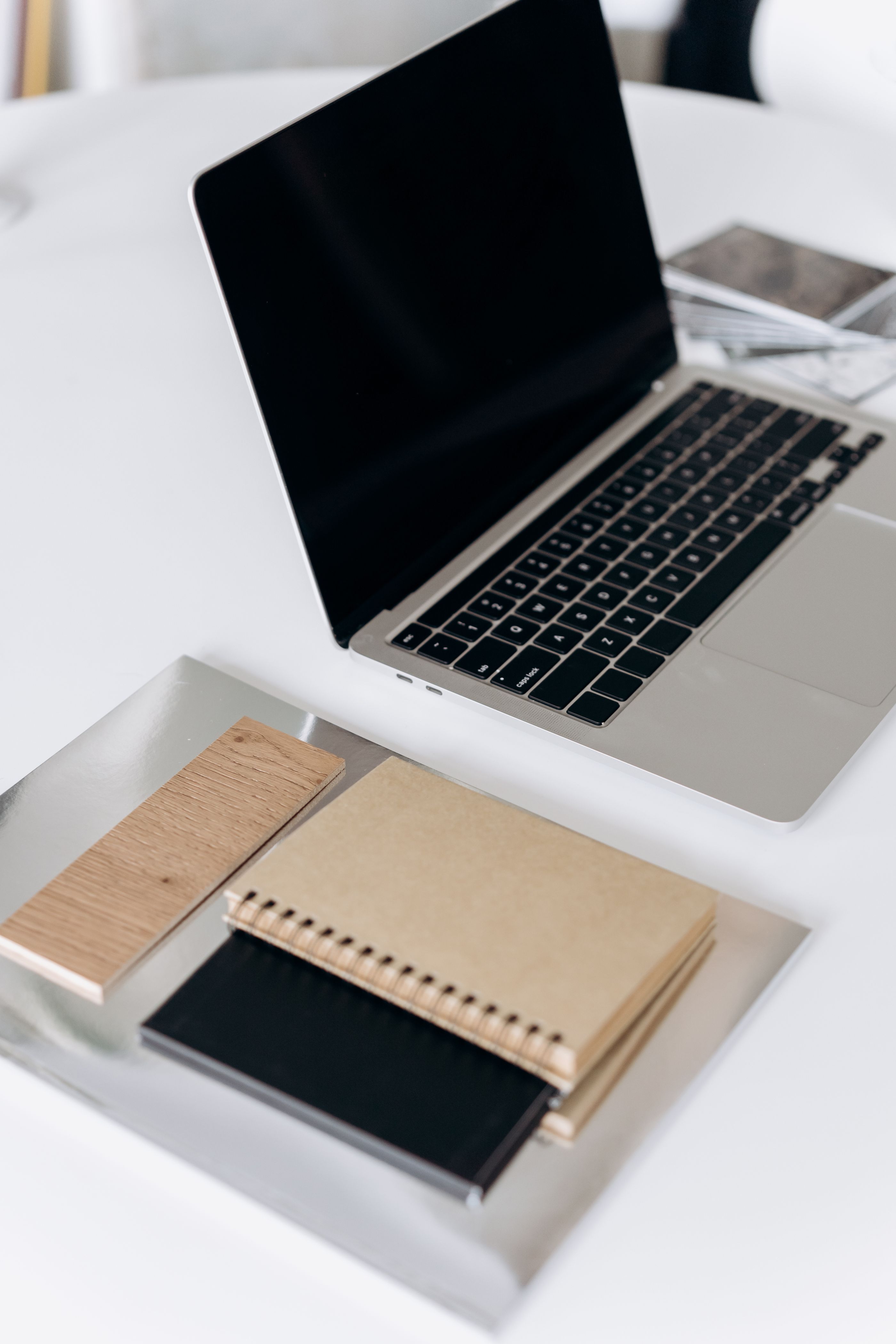 A neutral workspace with an open laptop and notebooks